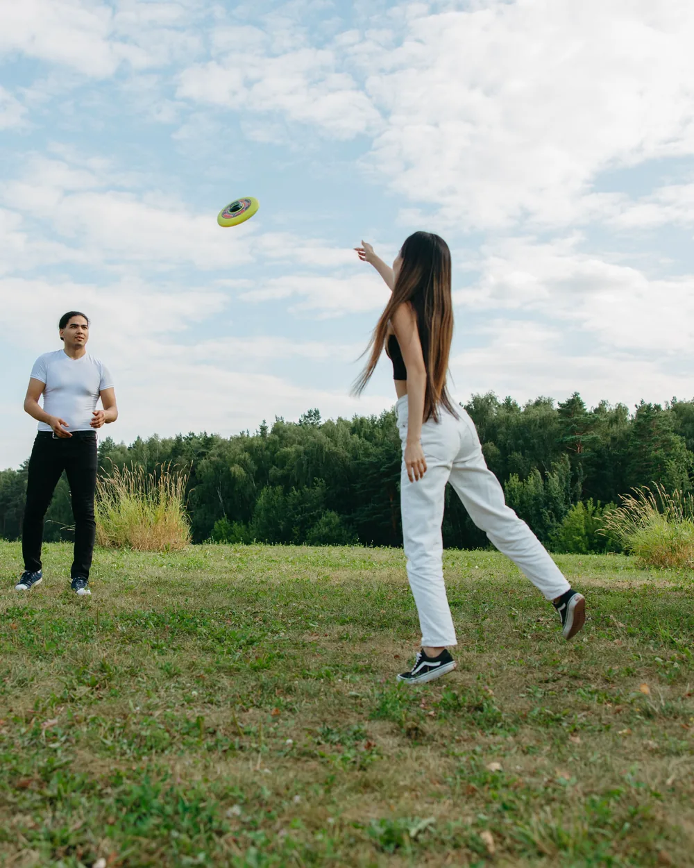 A player releasing a frisbee to a partner across a grass field